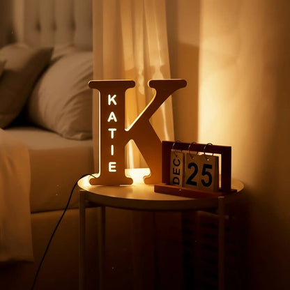 Custom name lamp Bedroom scene with a bed and decorative 'Katie' Lamp sign on a nightstand.